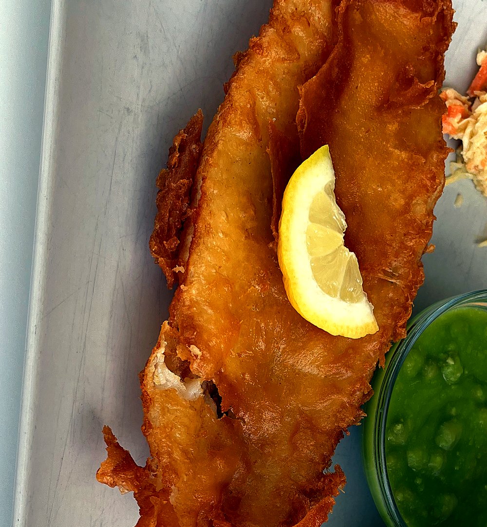Golden hand-battered cod with mushy peas, fresh to order